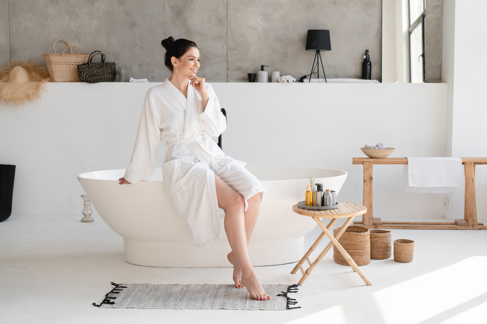 Woman sitting in robe with clear skin after hyperpigmentation treatment in LA