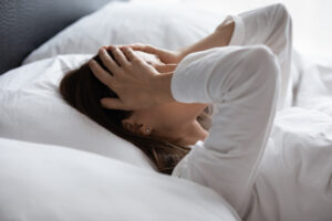Woman struggling to sleep due to restless leg syndrome in Los Angeles, CA